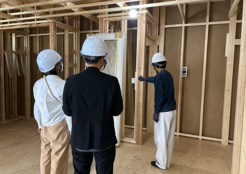 岩手の注文住宅の建築現場で、お施主様とスタッフがコンセントやスイッチの位置を確認している様子